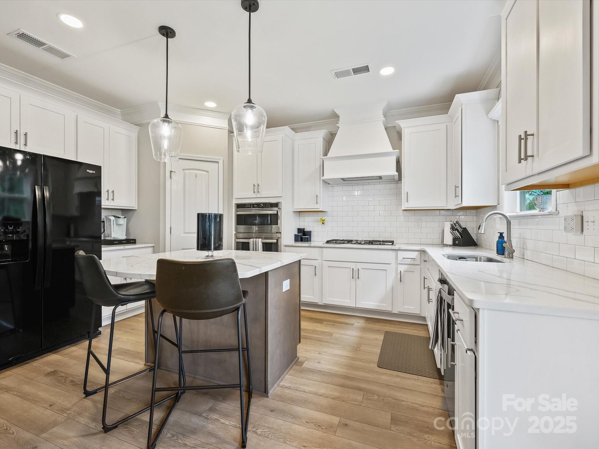 2901 South Point Road Belmont, NC 28012 - Photo 15 of 35 a kitchen with stainless steel appliances granite countertop a refrigerator a sink dishwasher a stove and white cabinets with wooden floor