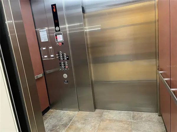 a view of a dining room and livingroom with furniture wooden floor a chandelier