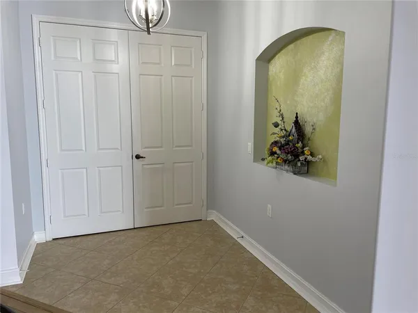 a dining room with wooden floor a chandelier a glass table and chairs