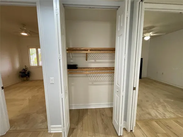 a view of empty room with wooden floor and a shower