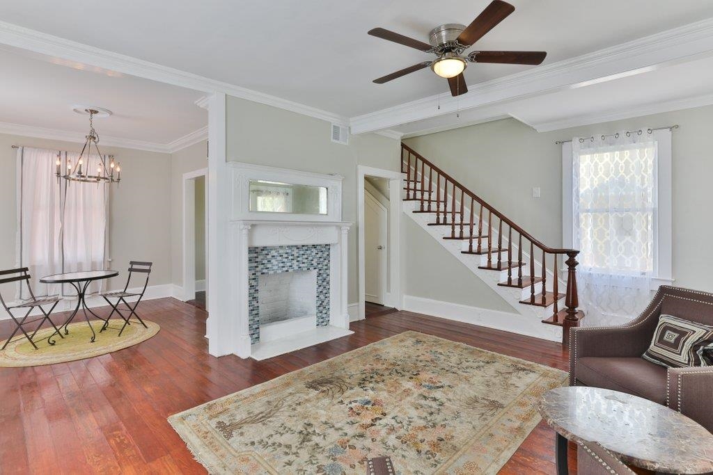 40 Abbott Street St. Augustine, FL 32084 - Photo 12 of 58 Living area with dark wood finished floors, ornamental molding, a chandelier, a tile fireplace, and stairway