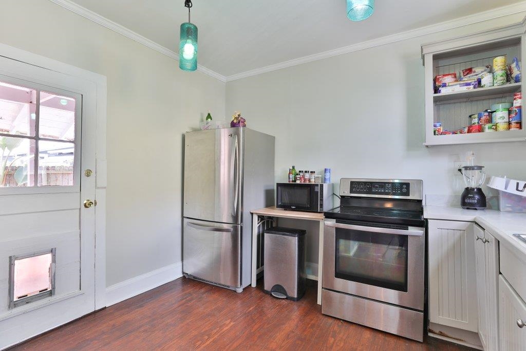 40 Abbott Street St. Augustine, FL 32084 - Photo 23 of 58 Kitchen with stainless steel appliances, ornamental molding, light countertops, dark wood finished floors, and white cabinets