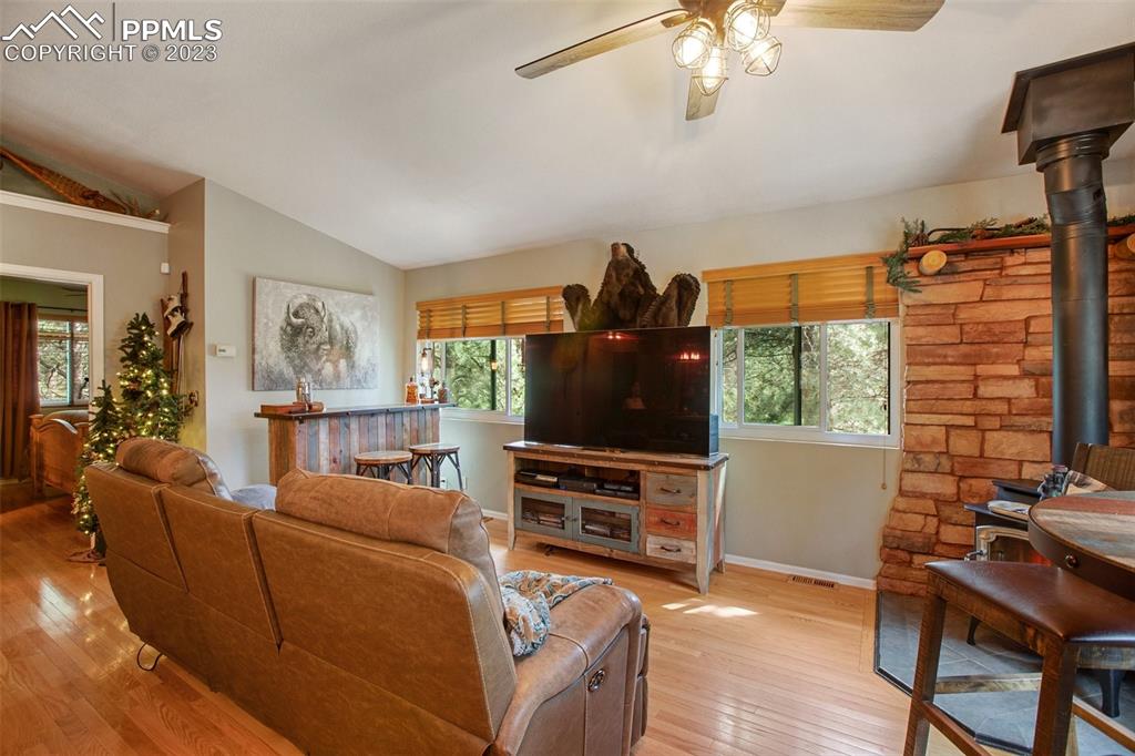 290 North Mountain Estates Road Florissant, CO 80816 - Photo 13 of 32 a living room with furniture a dining table and a flat screen tv with wooden floor