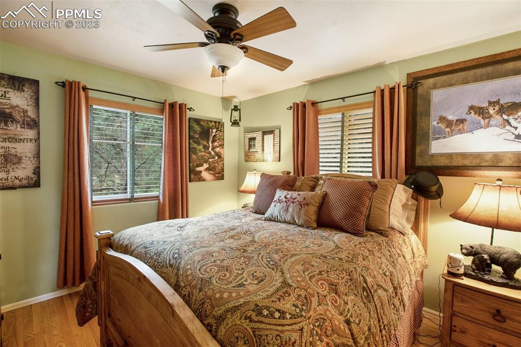 290 North Mountain Estates Road Florissant, CO 80816 - Photo 22 of 32 a bedroom with a large bed and a chandelier