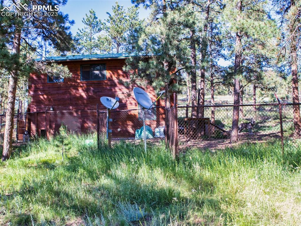 290 North Mountain Estates Road Florissant, CO 80816 - Photo 8 of 32 a backyard of a house with lots of green space and garden