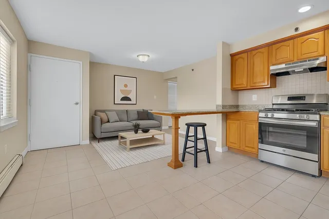 a living room with furniture a flat screen tv and kitchen view