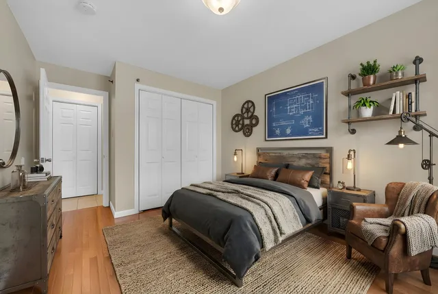 a bedroom with a bed a painting on the wall and a dresser