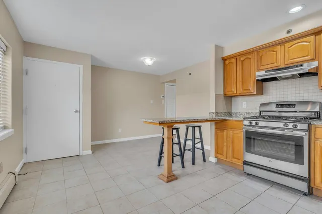 a kitchen with stainless steel appliances granite countertop a stove a sink and a refrigerator