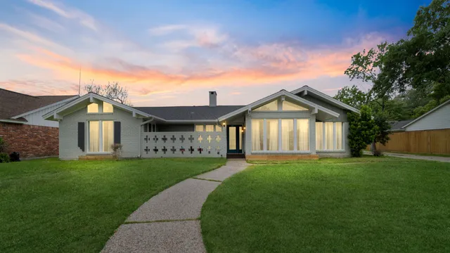a view of a big house with a big yard and large trees