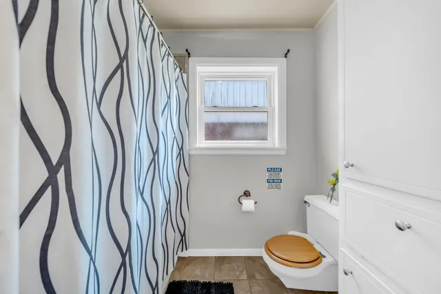 a bathroom with a toilet and a shower curtain