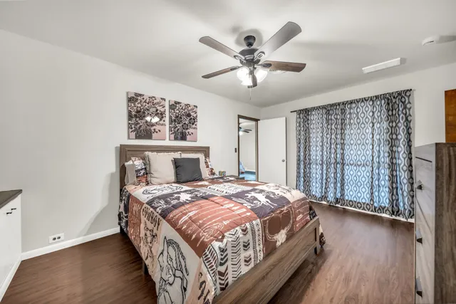 a bedroom with a large bed and a chandelier