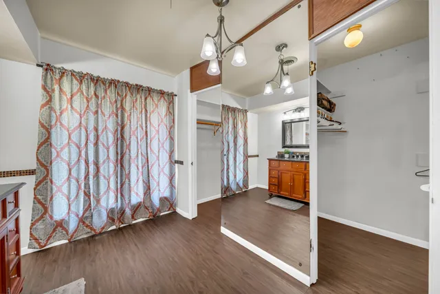 a view of a room with wooden floor staircase and a kitchen