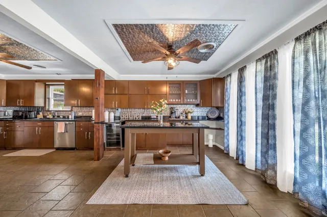 a living room with stainless steel appliances kitchen island granite countertop furniture and a view of kitchen