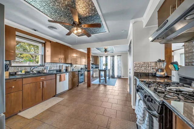 a large kitchen with stainless steel appliances granite countertop a stove granite counter tops and a view of living room