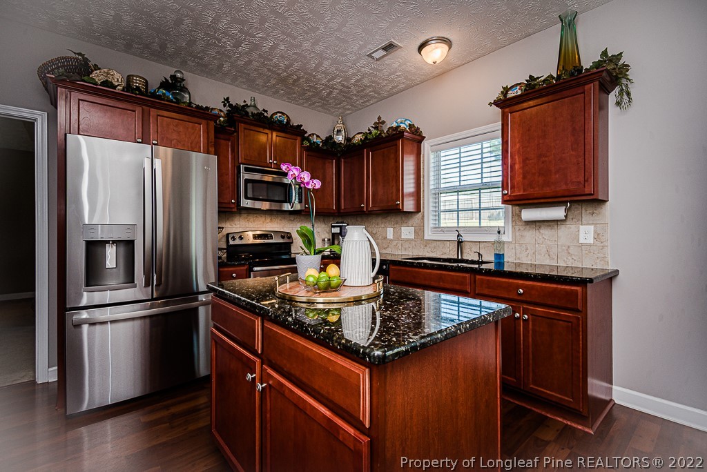 63 Colonist Place Cameron, NC 28326 - Photo 12 of 32 a kitchen with stainless steel appliances granite countertop a refrigerator a stove a sink and a microwave