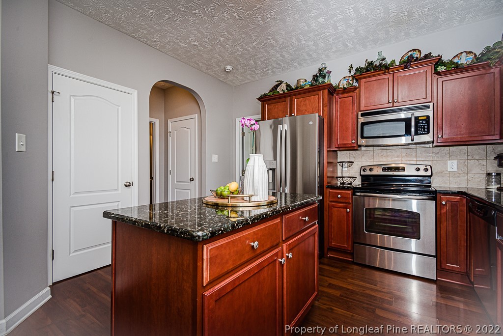 63 Colonist Place Cameron, NC 28326 - Photo 14 of 32 a kitchen with stainless steel appliances granite countertop a stove a sink and a microwave
