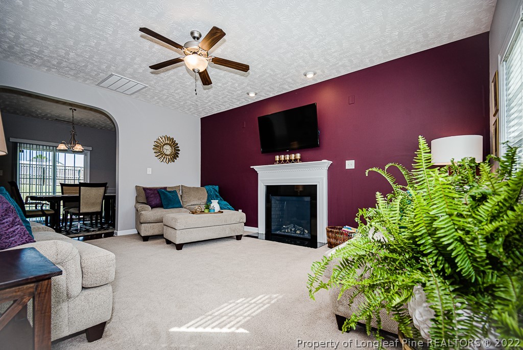 63 Colonist Place Cameron, NC 28326 - Photo 8 of 32 a living room with furniture a fireplace and a flat screen tv