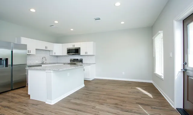 a kitchen with granite countertop a stove sink and cabinets