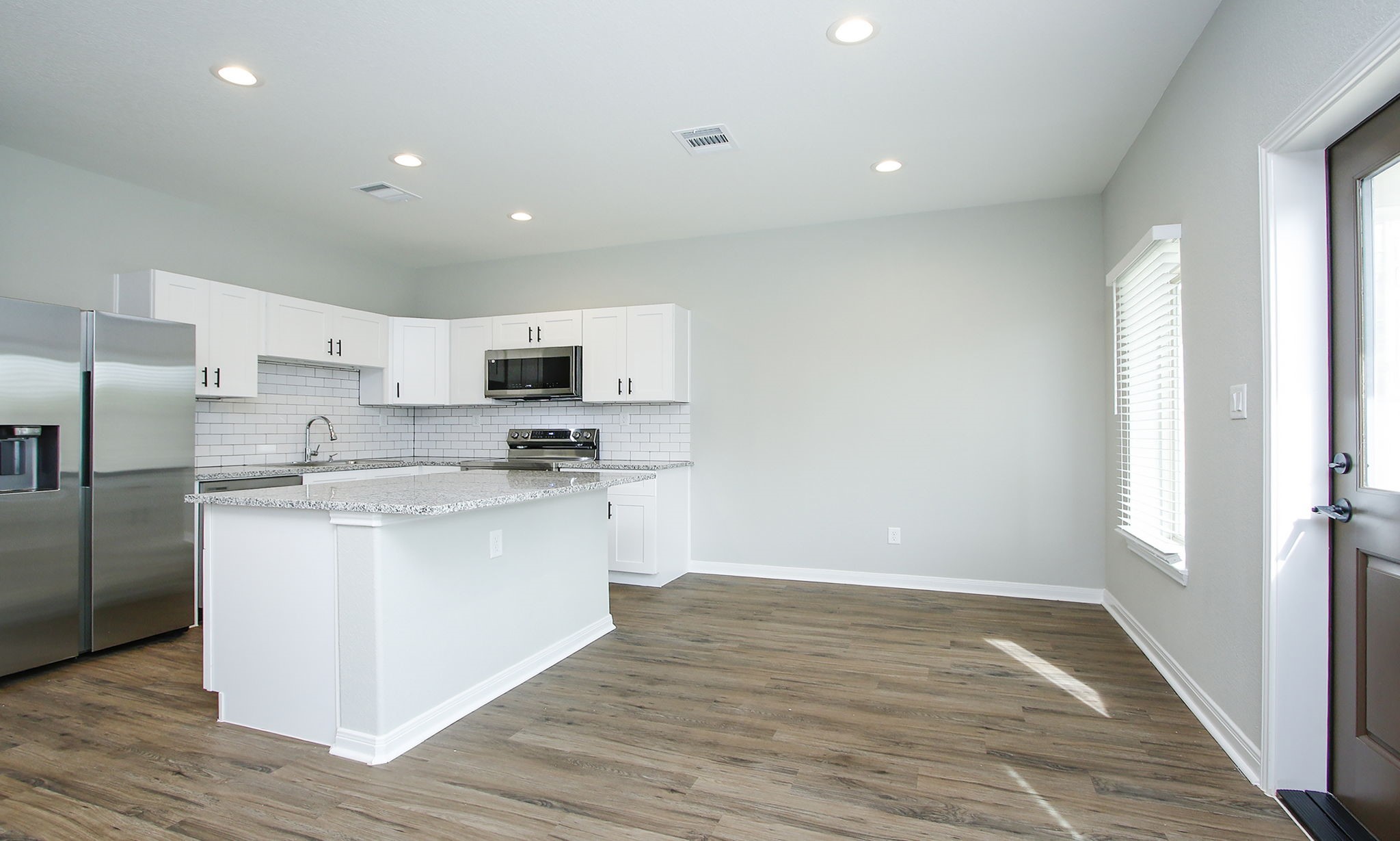 14010 Longstreet Road, Unit 9 Willis, TX 77318 - Photo 14 of 50 a kitchen with stainless steel appliances granite countertop a refrigerator sink and white cabinets