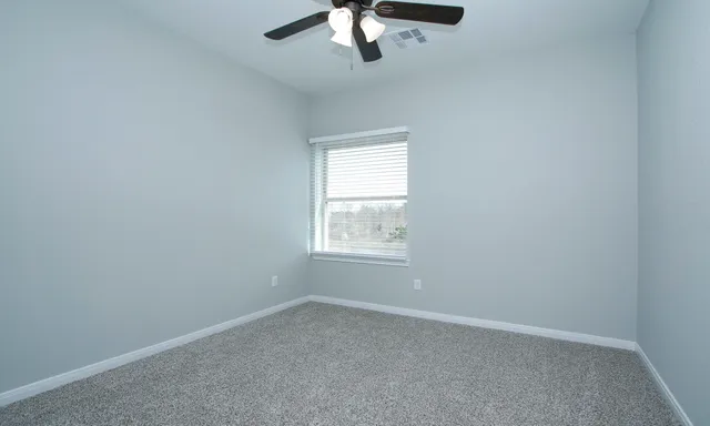 an empty room with a empty space and a ceiling fan