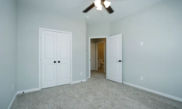 an empty room with a ceiling fan and a window