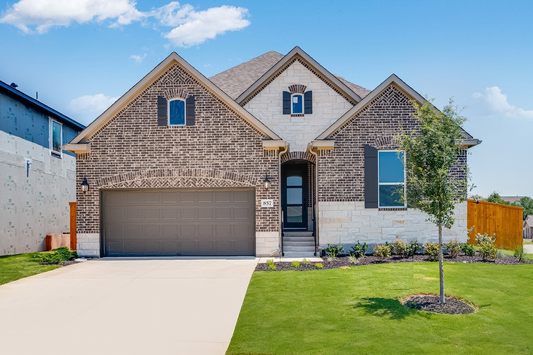 a front view of a house with a yard and garage