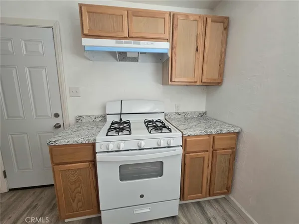 a kitchen with granite countertop white cabinets and white stove