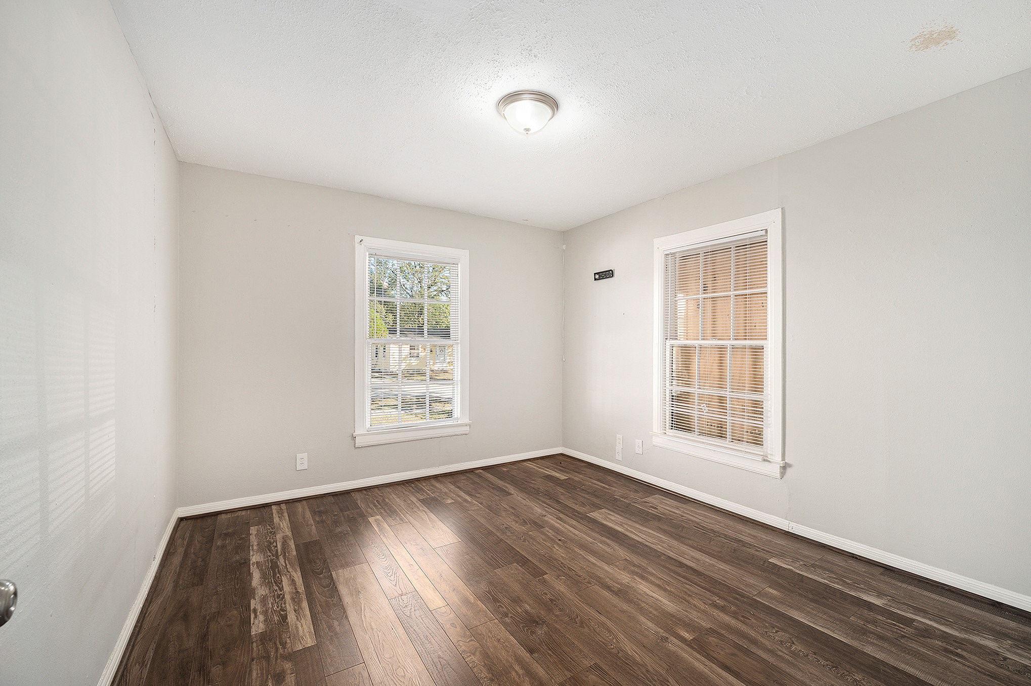 10406 Wiggins Street Houston, TX 77029 - Photo 10 of 12 an empty room with wooden floor and windows