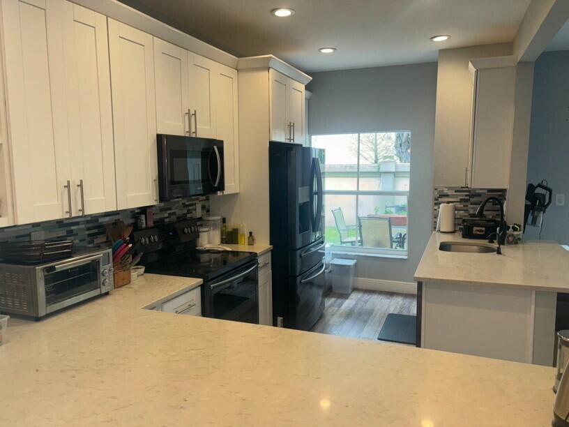 a kitchen with stainless steel appliances a stove sink and microwave