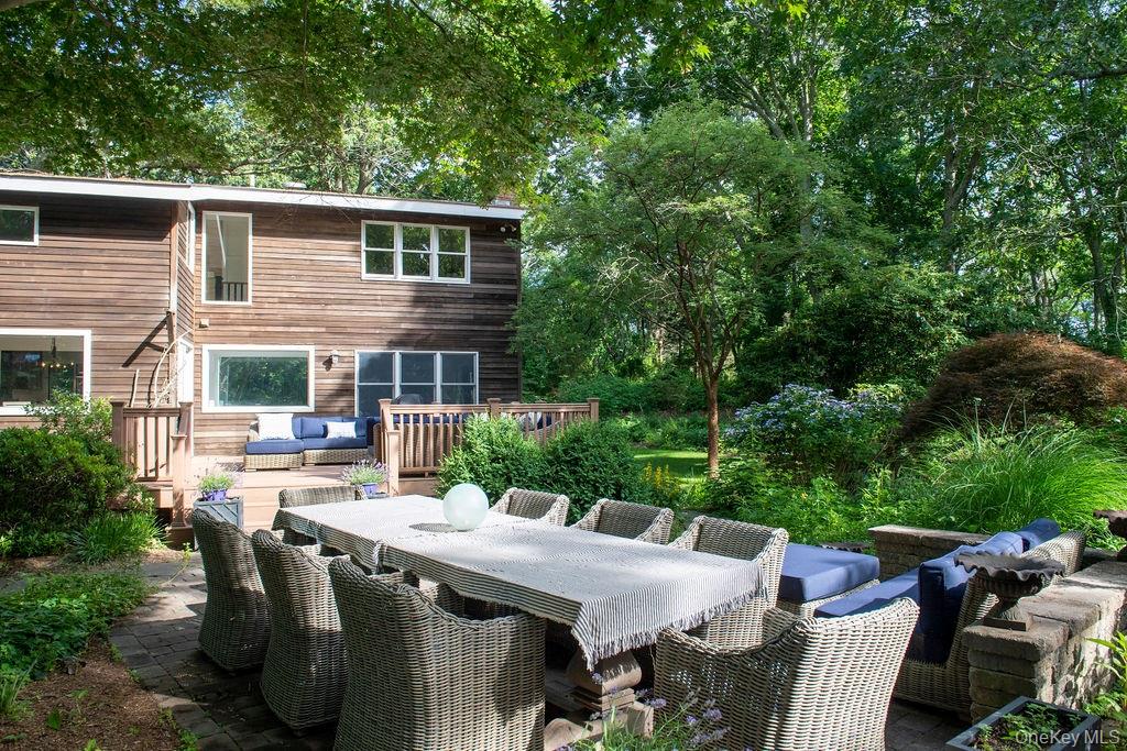 a view of a patio with table and chairs with wooden fence and plants