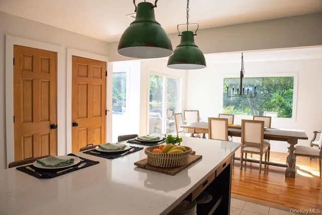 a living room with furniture kitchen view and a large window