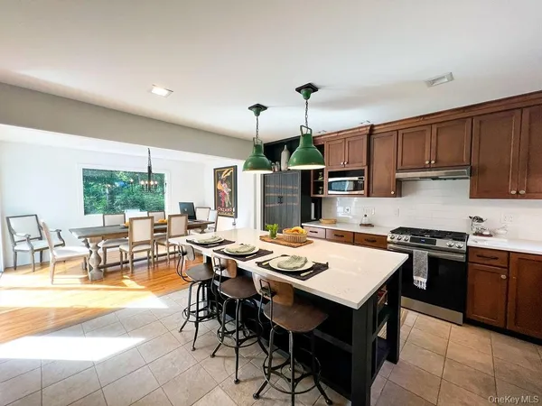 a kitchen with stainless steel appliances a stove a refrigerator and a dining table