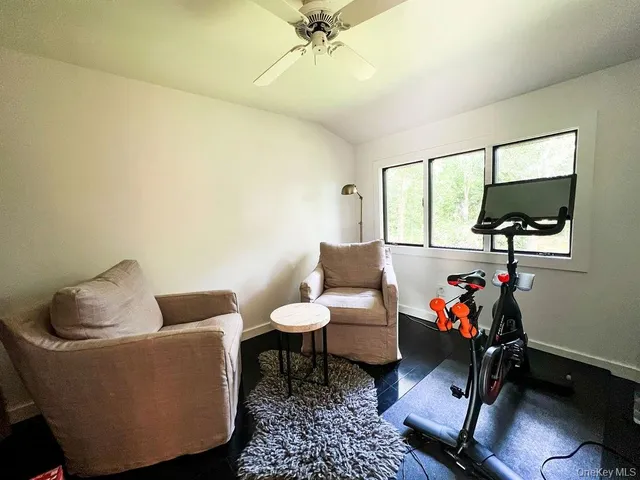 a bedroom with furniture flat screen tv and a window