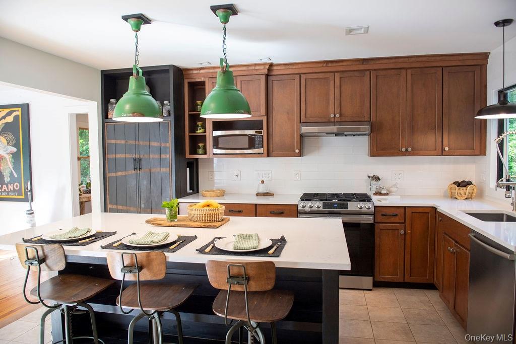 1045 Wagon Wheel Lane Cutchogue, NY 11935 - Photo 10 of 31 a kitchen with a table chairs stove and microwave