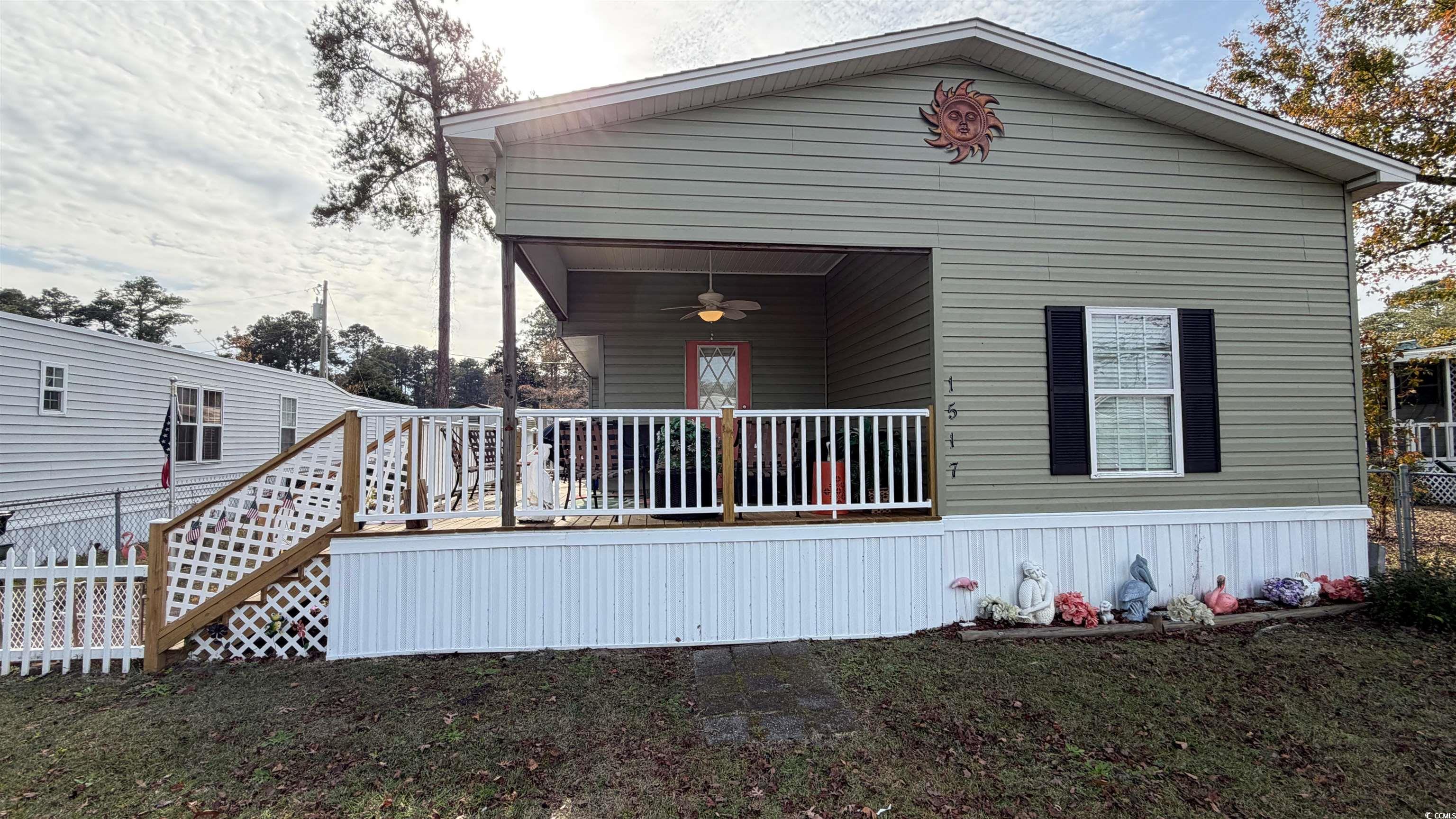 View of front of property with ceiling fan and a deck