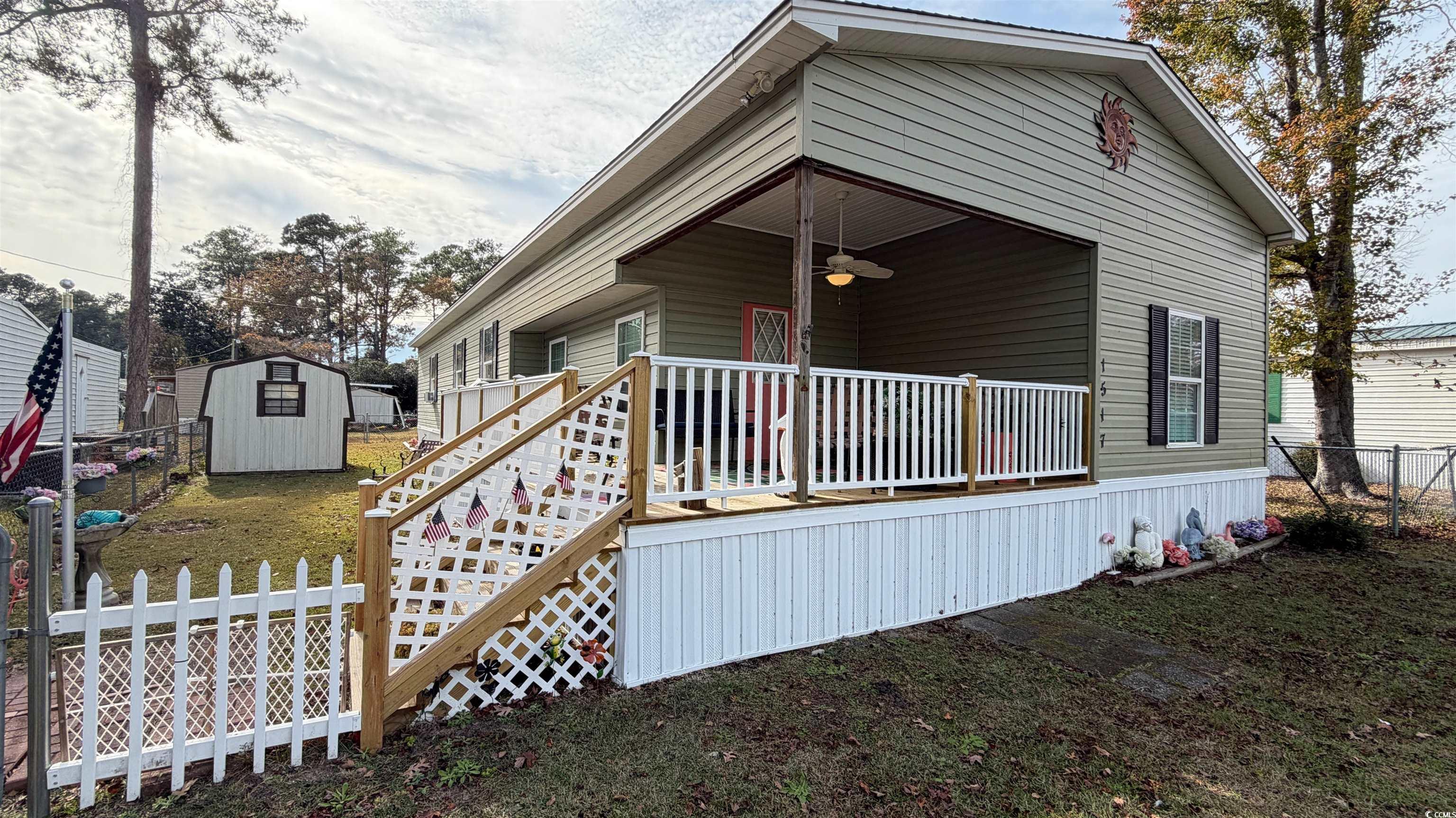1517 Pisces Lane Myrtle Beach, SC 29575 - Photo 27 of 30 View of front of house featuring a ceiling fan, a storage unit, a wooden deck, and stairway