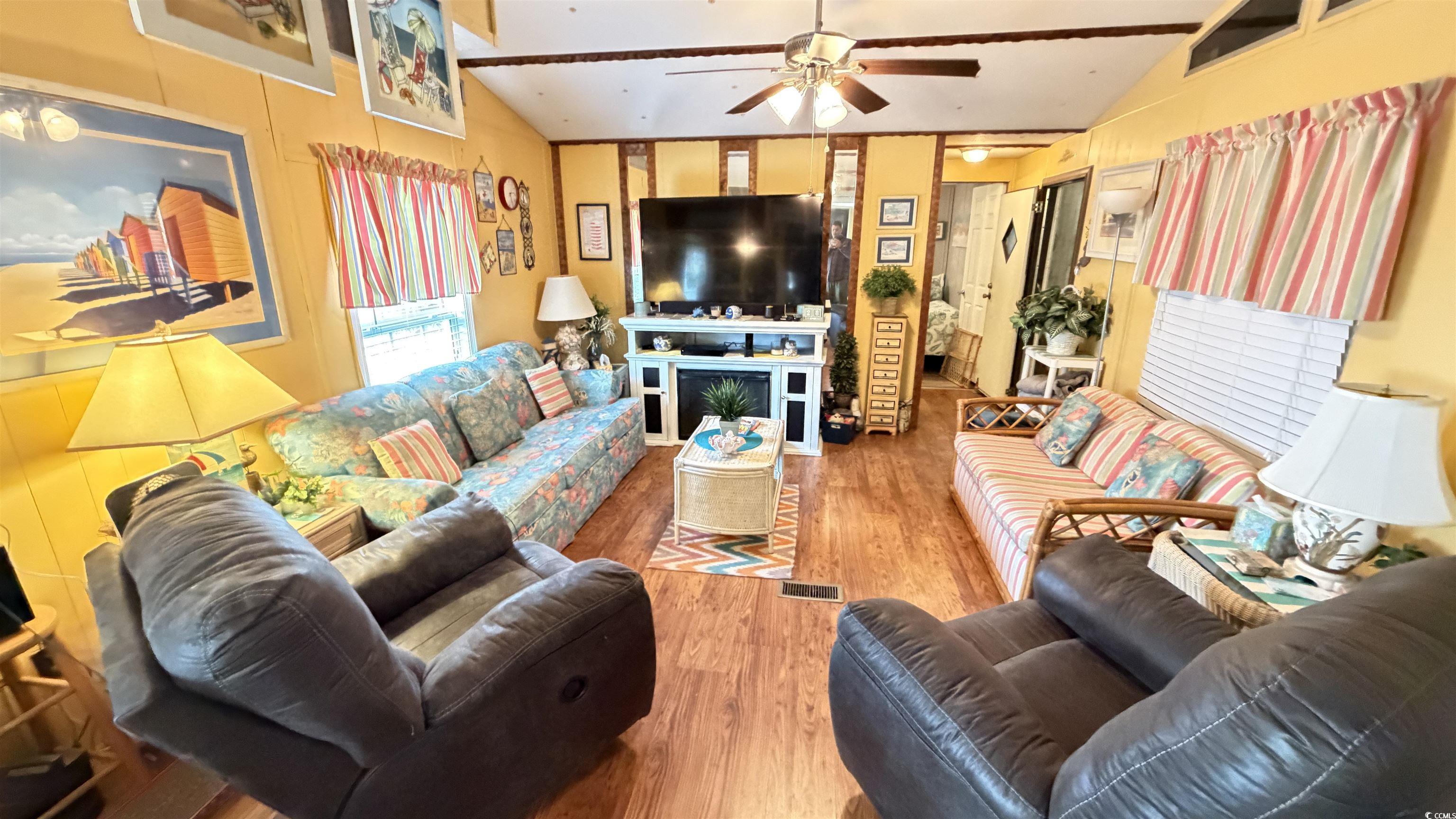 1517 Pisces Lane Myrtle Beach, SC 29575 - Photo 3 of 30 Living area featuring lofted ceiling, wood finished floors, and ceiling fan