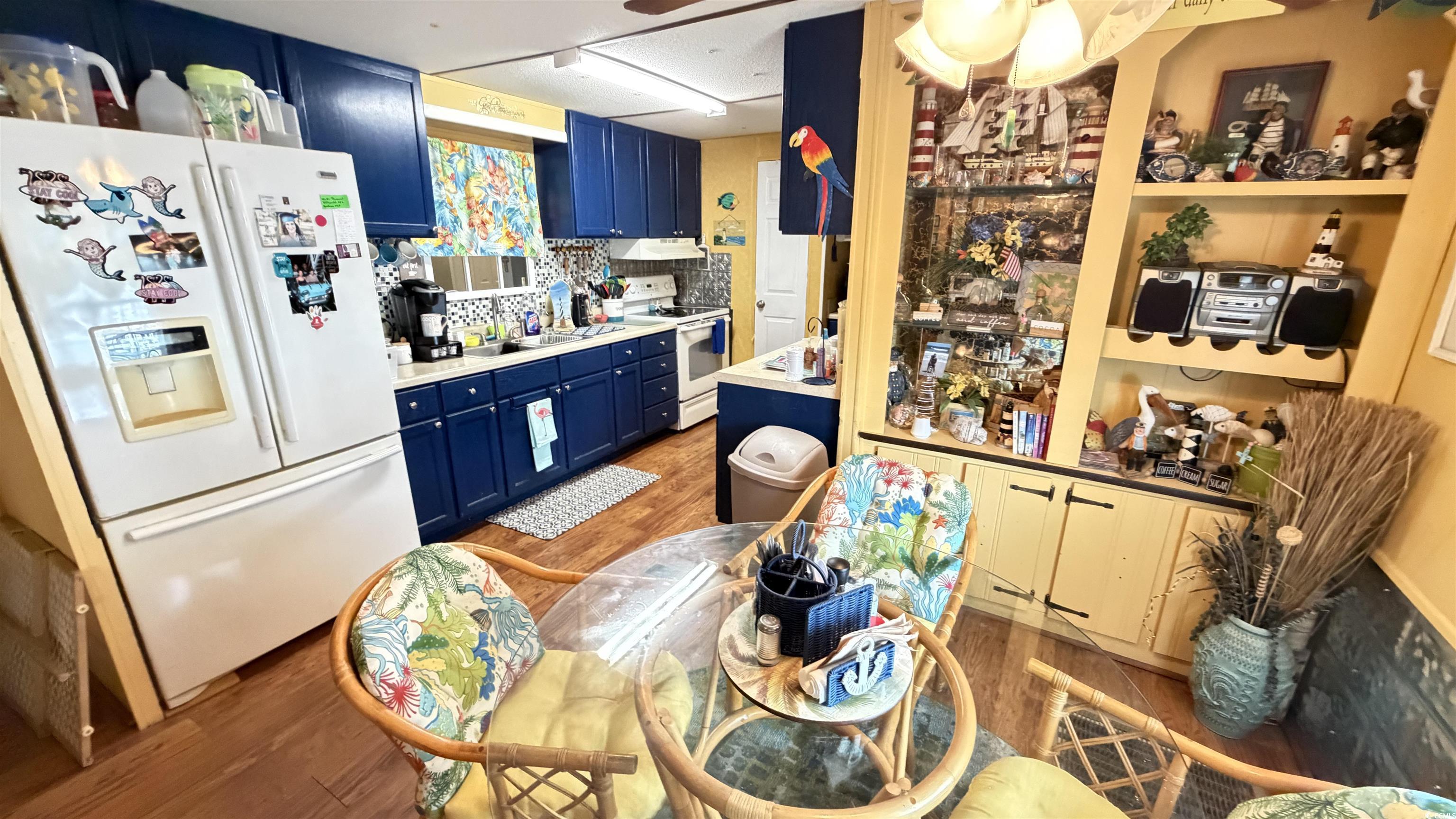 1517 Pisces Lane Myrtle Beach, SC 29575 - Photo 5 of 30 Kitchen featuring blue cabinetry, white appliances, light countertops, and light wood finished floors