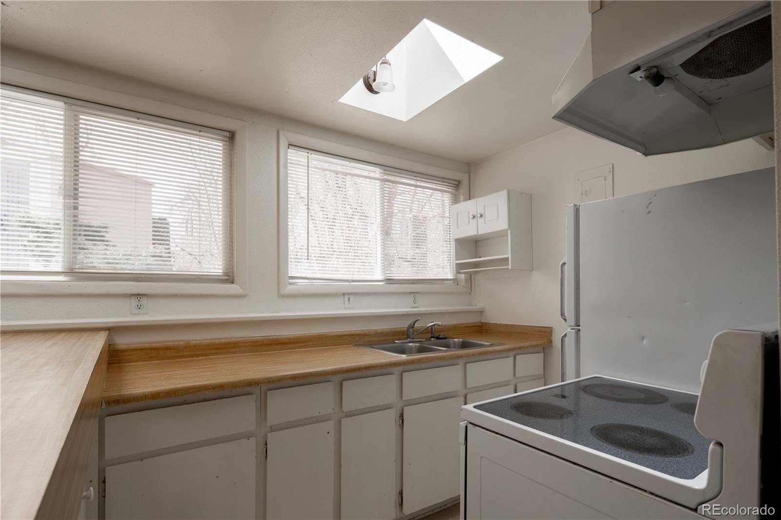 3413 Wadsworth Boulevard Wheat Ridge, CO 80033 - Photo 19 of 25 a kitchen that has a sink and a stove