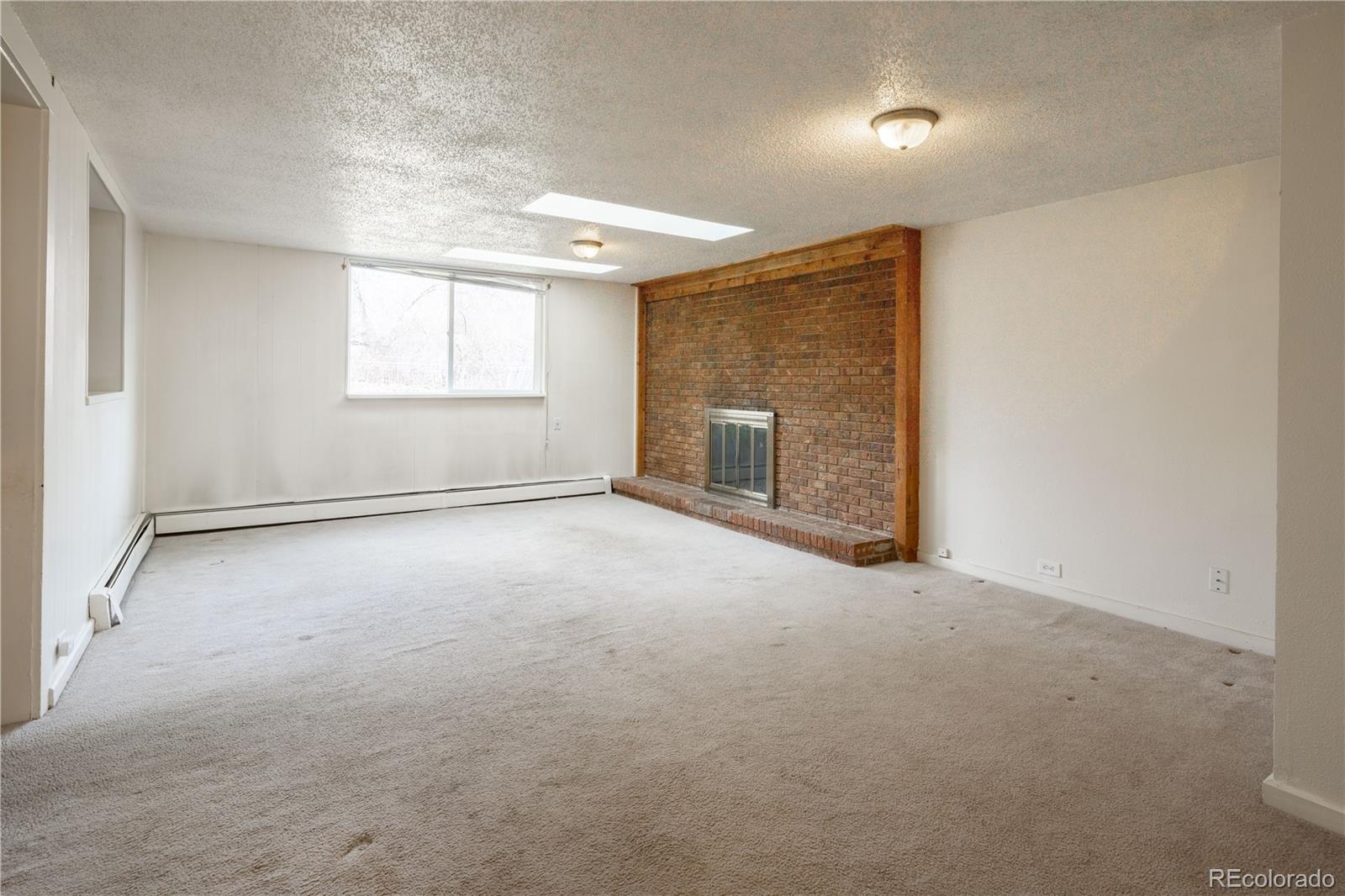 3413 Wadsworth Boulevard Wheat Ridge, CO 80033 - Photo 7 of 25 an empty room with windows and fireplace