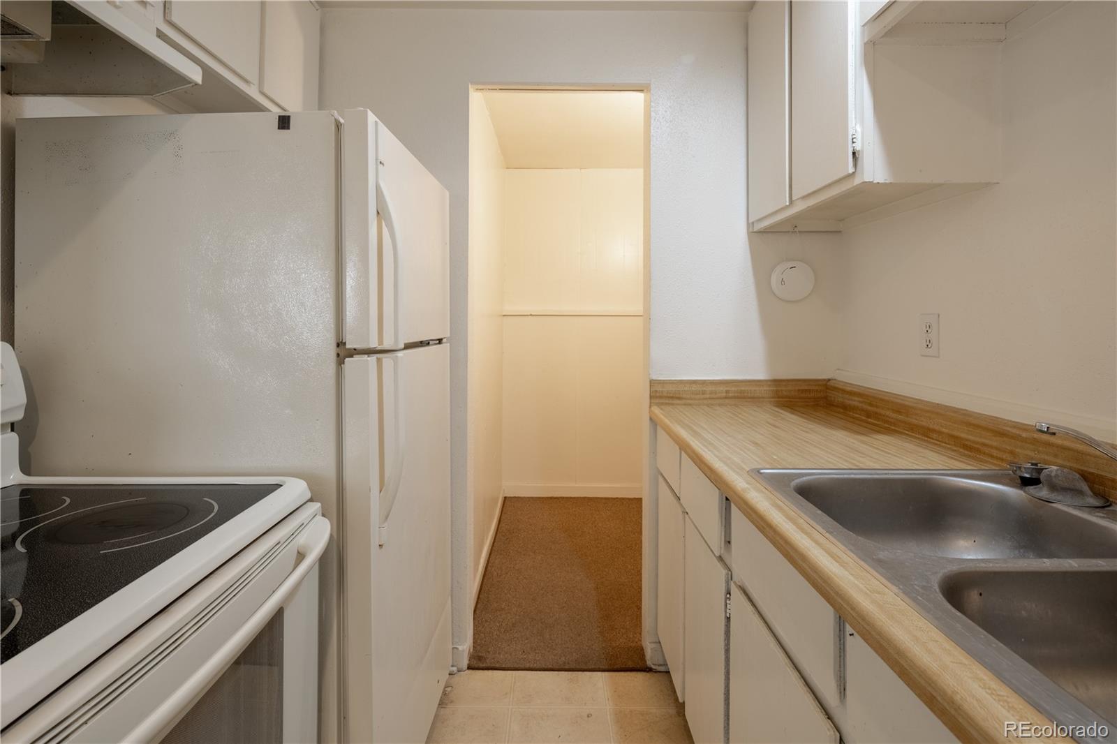 3413 Wadsworth Boulevard Wheat Ridge, CO 80033 - Photo 9 of 25 a kitchen with a sink and a refrigerator