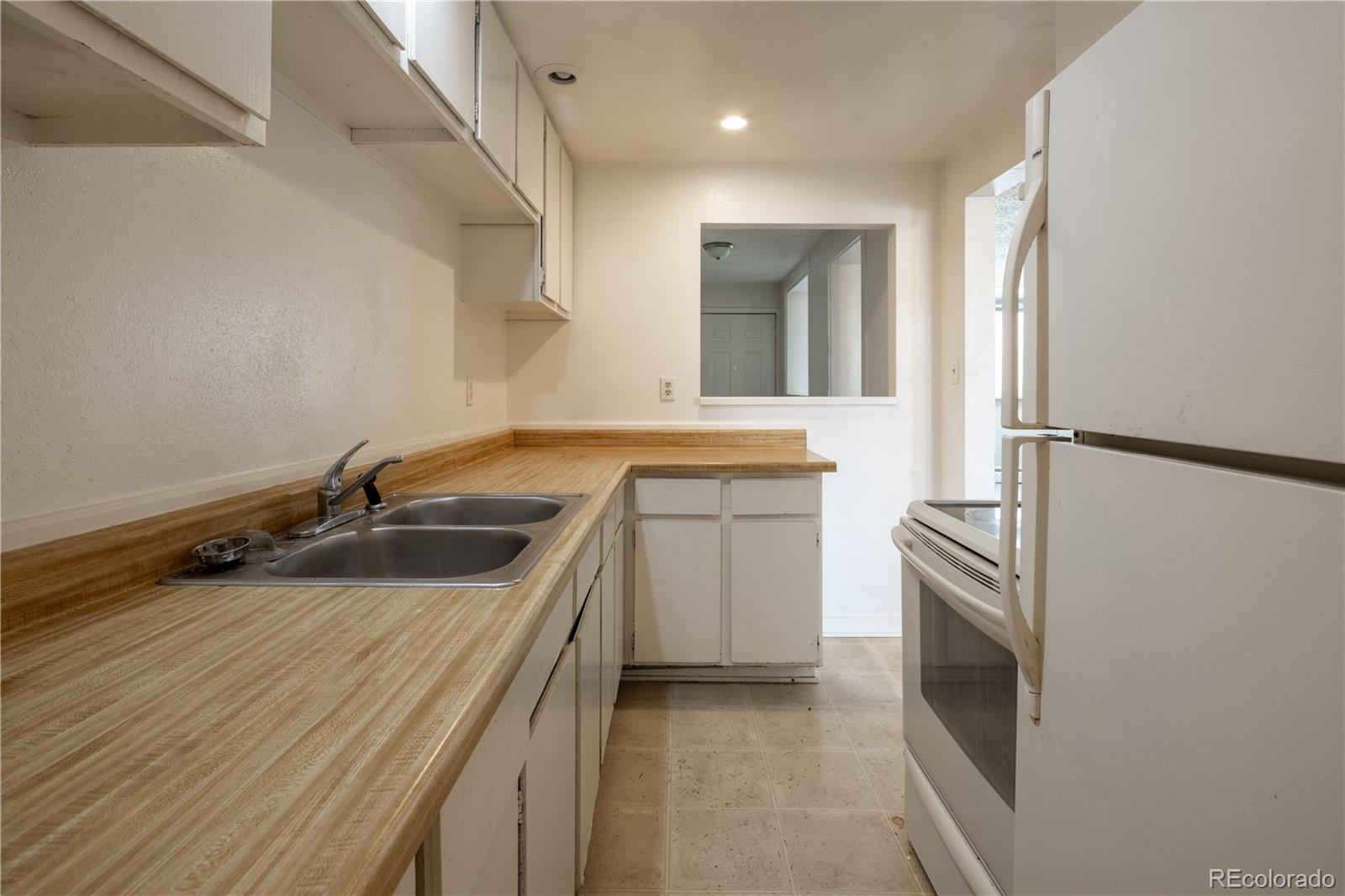 3413 Wadsworth Boulevard Wheat Ridge, CO 80033 - Photo 10 of 25 a kitchen with a sink stove and refrigerator