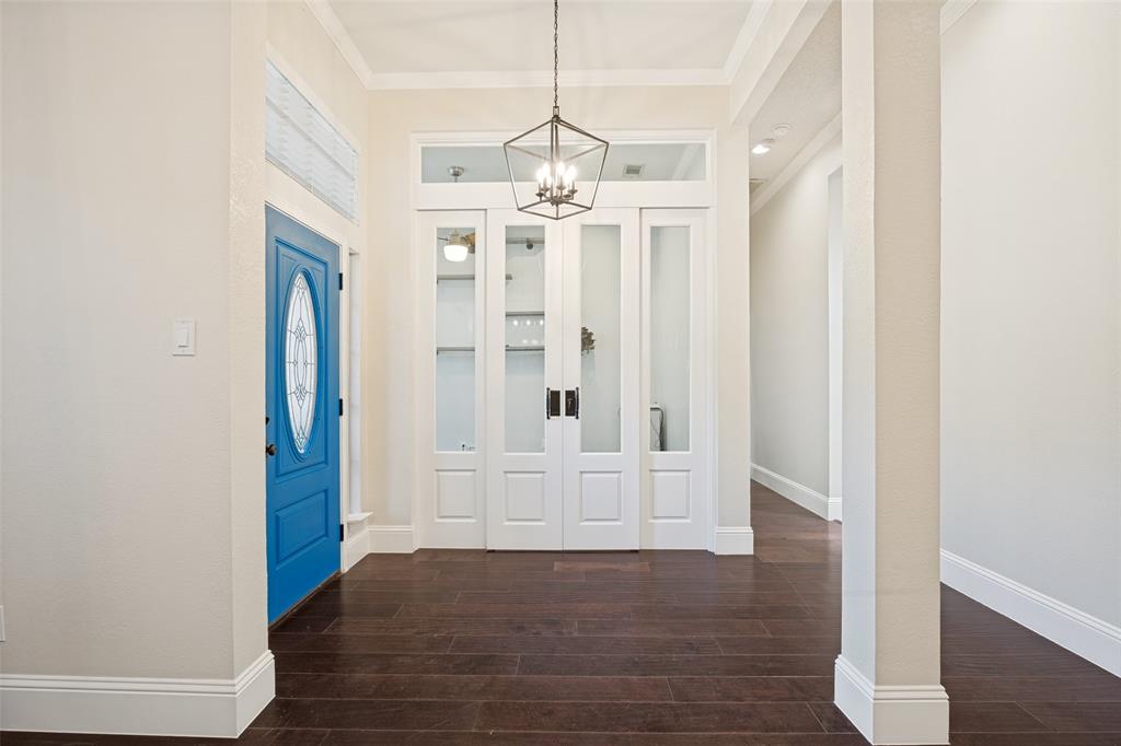 2100 Los Rios Boulevard Plano, TX 75074 - Photo 3 of 25 Entryway featuring a bright blue oval-lite door, dark wood-finish flooring, and a modern geometric pendant light fixture