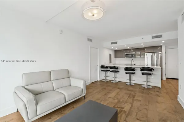 a living room with furniture kitchen view and a table