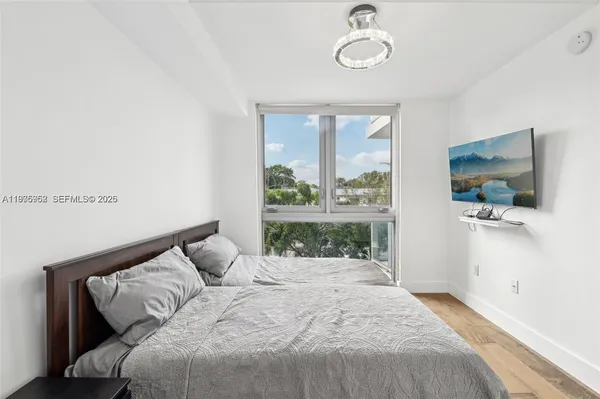 a bedroom with a large bed and a flat tv screen