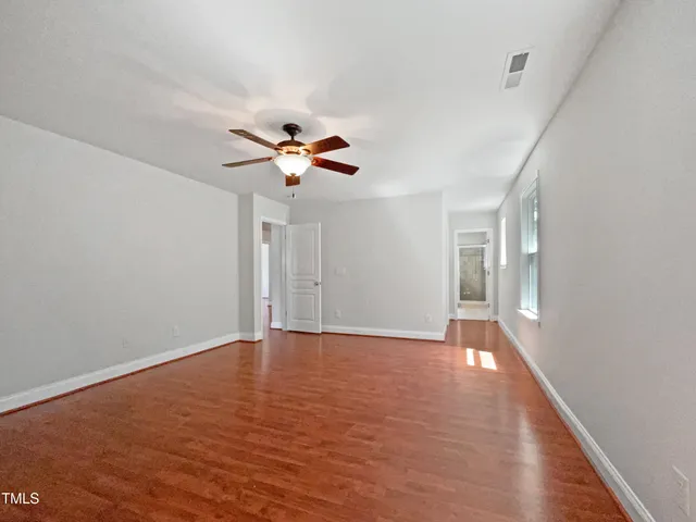 a view of an empty room with wooden floor