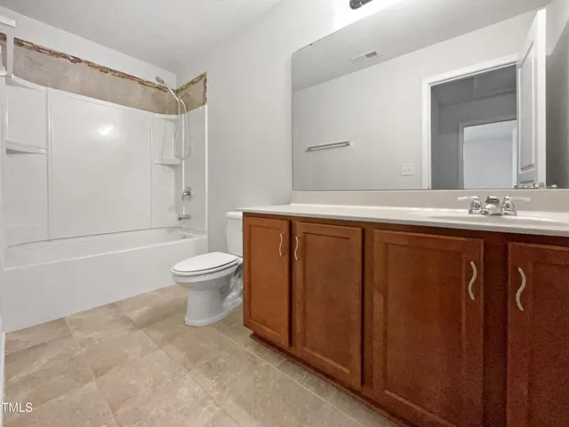 a spacious bathroom with a sink a toilet a mirror and a shower