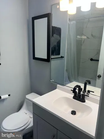 a bathroom with a sink toilet and mirror