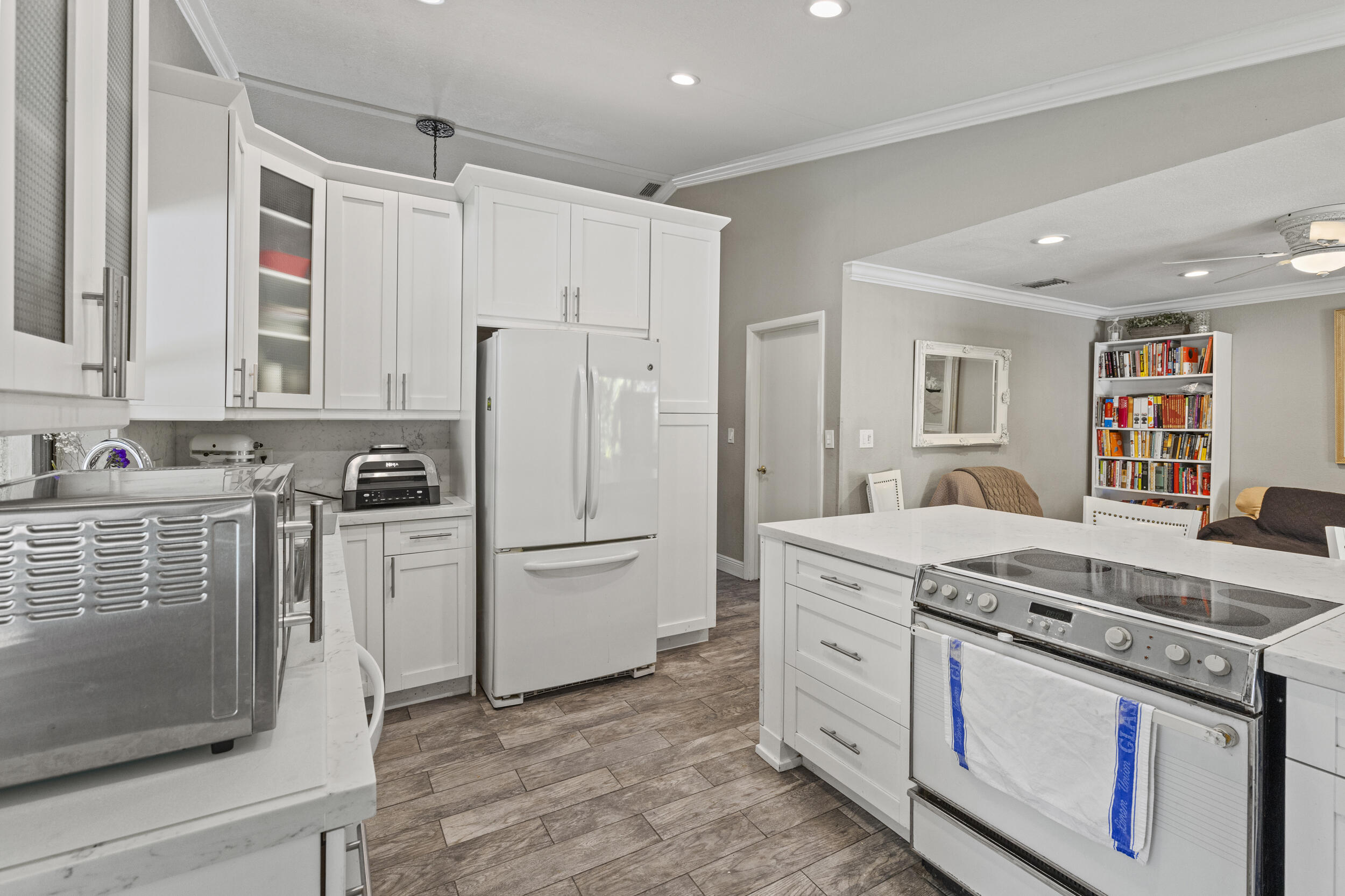 21665 Sutters Lane Boca Raton, FL 33428 - Photo 12 of 42 a kitchen with white cabinets and white appliances