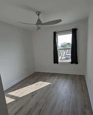 a view of a room with wooden floor closet and windows